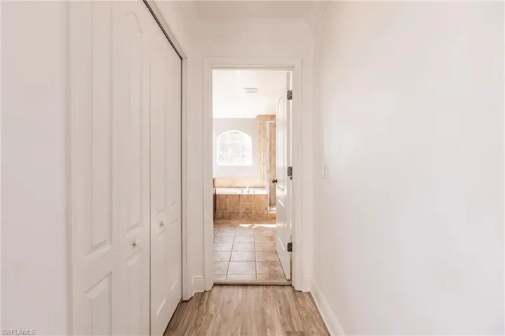 Hall featuring ornamental molding and light hardwood / wood-style flooring