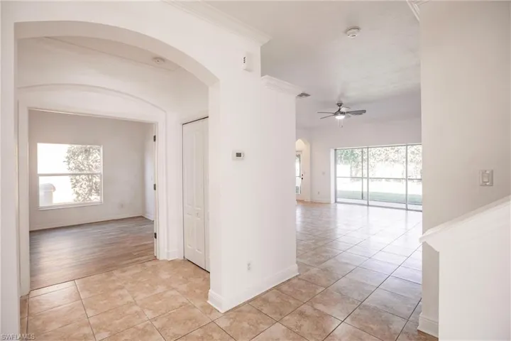 Unfurnished room with ceiling fan, light wood-type flooring, crown molding, and a wealth of natural light