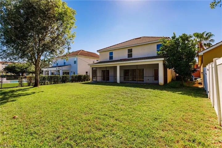 Rear view of house with a yard and a sunroom
