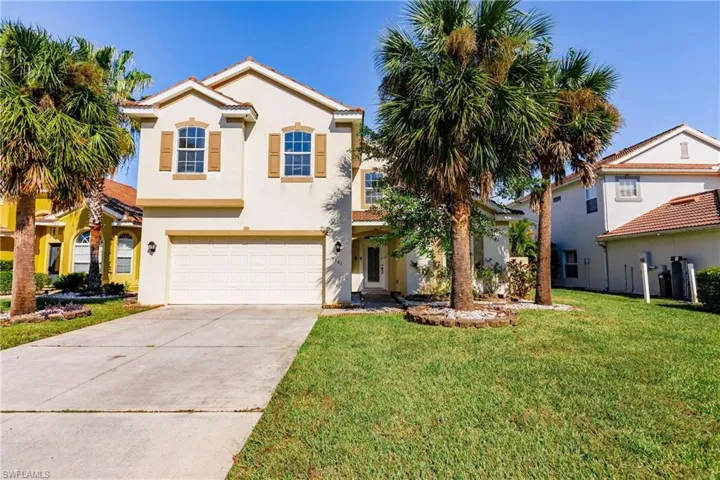 Mediterranean / spanish-style home with a front yard and a garage