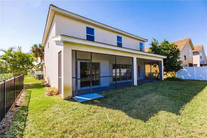 Back of property featuring a lawn and a sunroom