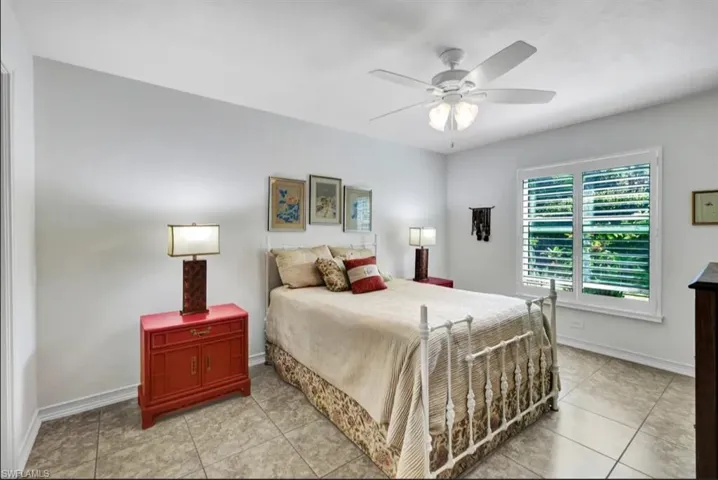 Bedroom featuring a ceiling fan, baseboards, and light tile patterned floors