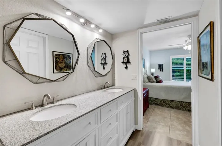 Ensuite bathroom with ceiling fan, ensuite bath, a sink, and double vanity