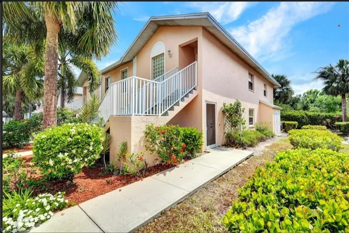 View of front of home with stucco siding and stairway