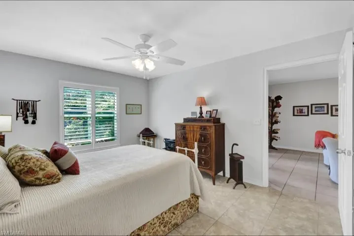 Bedroom with a ceiling fan and light tile patterned flooring