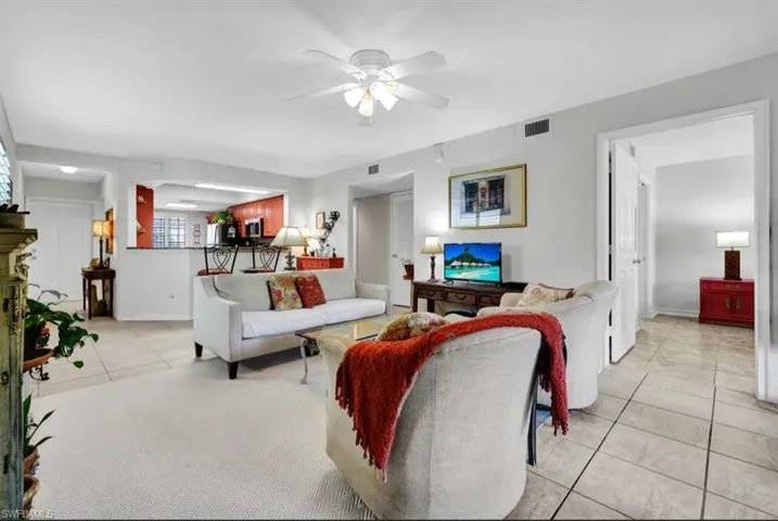 Living area featuring visible vents, baseboards, ceiling fan, and light tile patterned floors