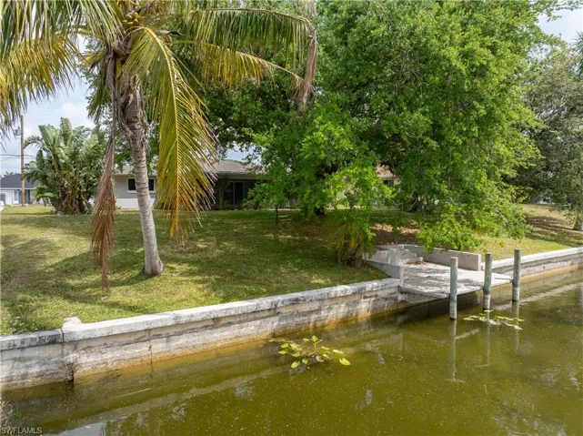 Dock area featuring a lawn and a water view