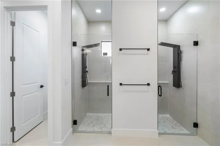 Full double master bathroom with a stall shower, light tile patterned floors, and recessed lighting