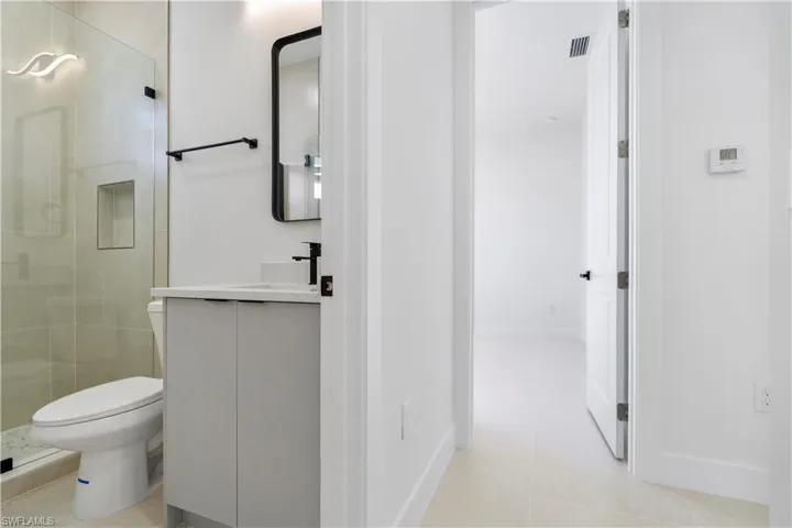 Bathroom featuring vanity, a stall shower, and light tile patterned flooring