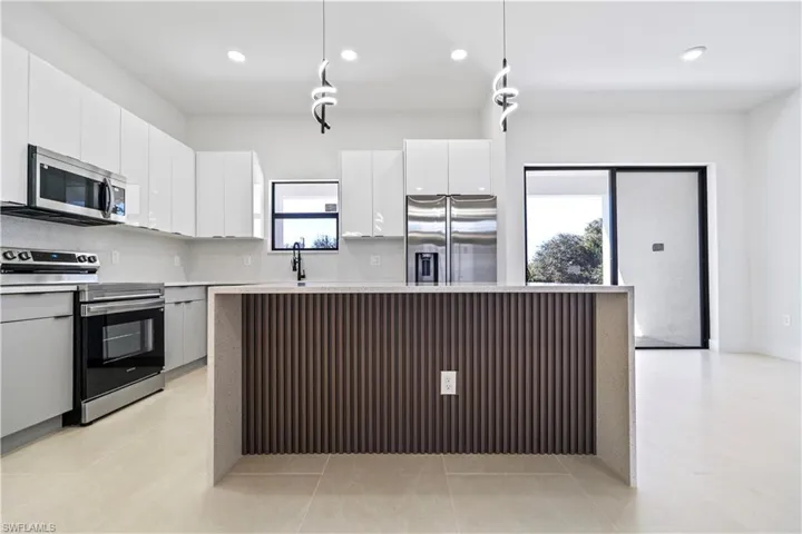 Kitchen featuring stainless steel appliances, modern cabinets, a kitchen island, healthy amount of natural light, and recessed lighting