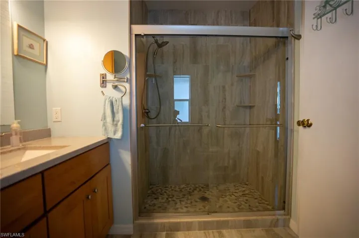 Bathroom featuring vanity and a shower stall