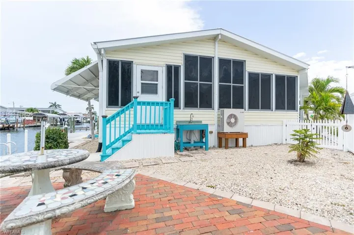 View of front facade with a sunroom and a water view