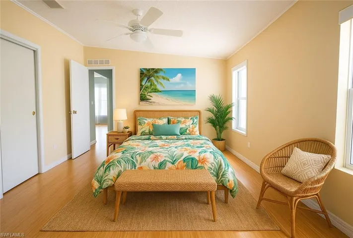 Bedroom featuring light wood-type flooring, crown molding, and ceiling fan