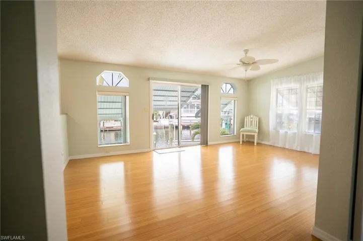 Spare room featuring a textured ceiling, ceiling fan, and light wood-type flooring