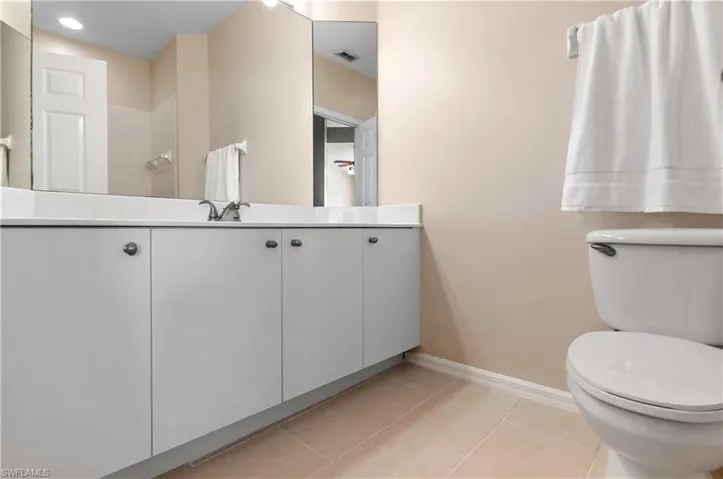 Full bath featuring light tile patterned floors, vanity, and walk in shower
