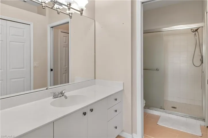 Bathroom featuring vanity, a stall shower, and light tile patterned floors