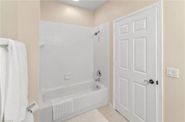 Full bath featuring light tile patterned floors and shower / tub combination