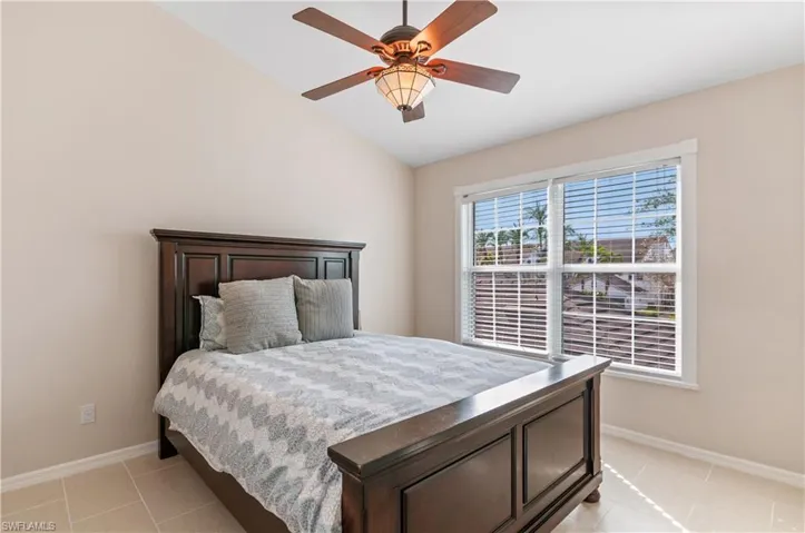 Bedroom featuring light tile patterned flooring, a ceiling fan, and lofted ceiling