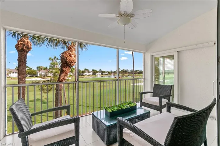 Sunroom / solarium featuring a water view, vaulted ceiling, and view of golf course