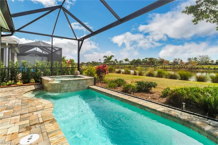 View of swimming pool featuring an in ground hot tub and a lanai