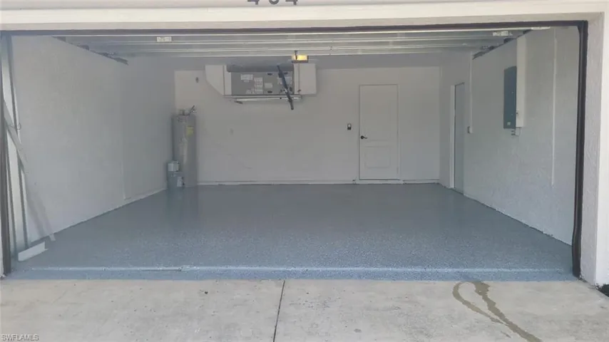 Garage featuring water heater and electric panel