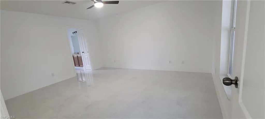 Unfurnished room with ceiling fan and concrete flooring