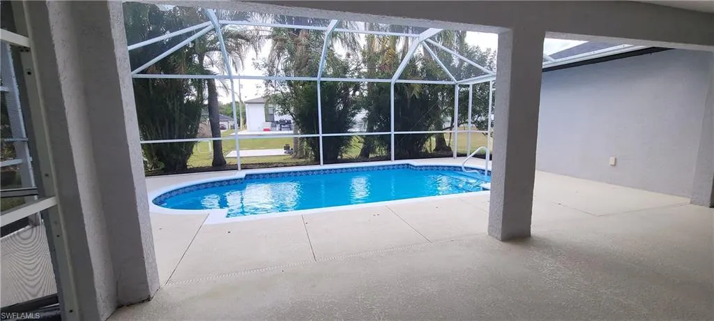 Outdoor pool featuring a patio, glass enclosure, and a sunroom