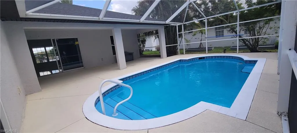 Outdoor pool featuring a sunroom, a lanai, and a patio area