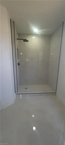 Bathroom featuring a stall shower and baseboards