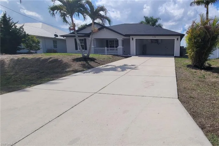 Single story home with a garage, concrete driveway, stucco siding, and a front lawn