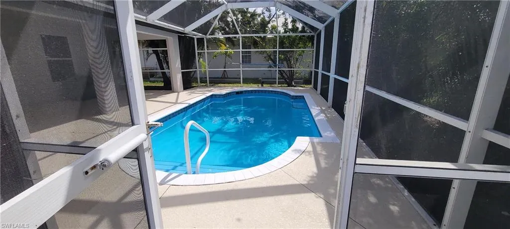Swimming pool featuring a lanai, a sunroom, and a patio