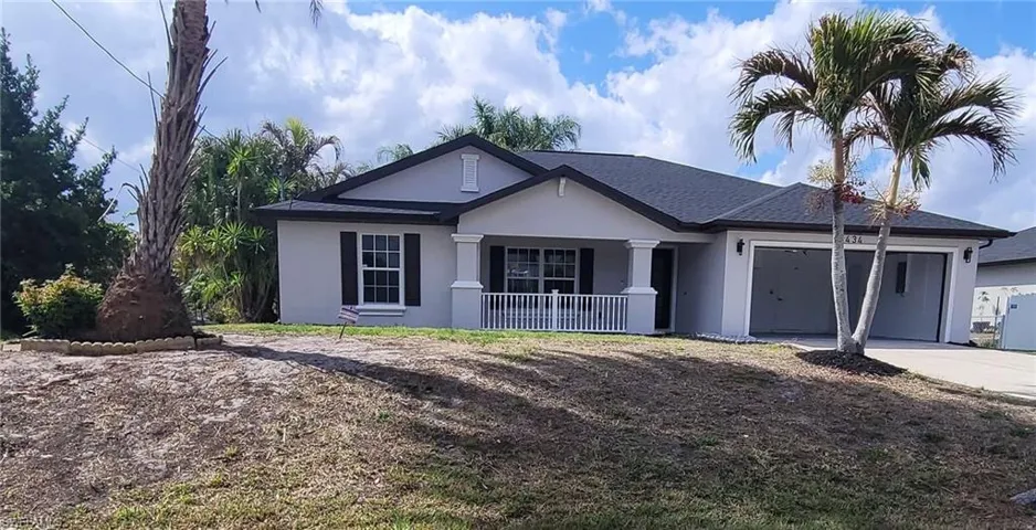 Single story home with a garage, stucco siding, driveway, and covered porch