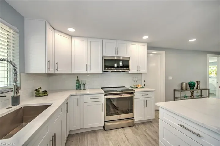 Kitchen featuring appliances with stainless steel finishes, white cabinetry, and sink