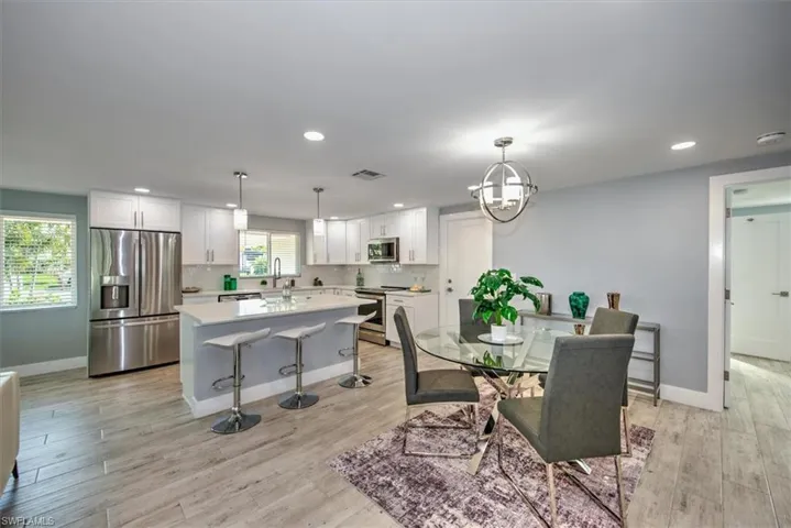 Dining area featuring sink, light hardwood / wood-style floors, and a notable chandelier