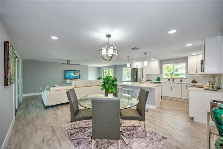 Dining room featuring ceiling fan with notable chandelier, light hardwood / wood-style flooring, and sink