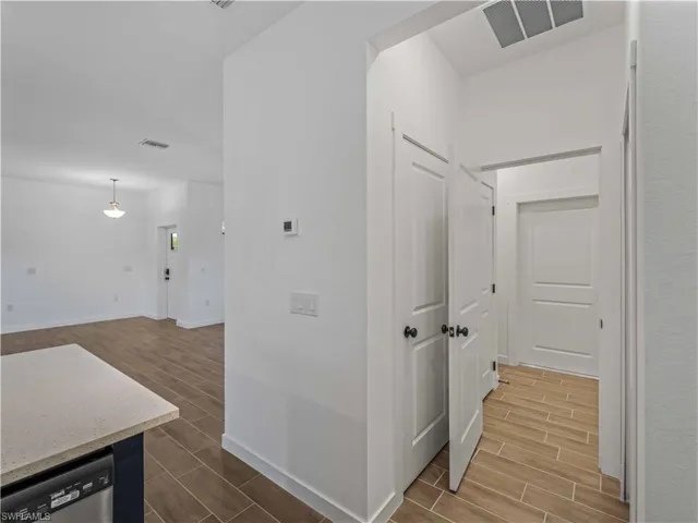 Hallway featuring wood tiled floors and baseboards