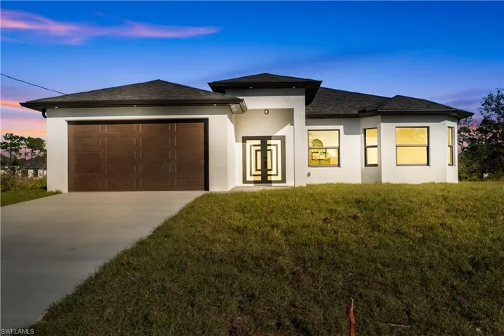 Prairie-style home featuring a lawn and a garage