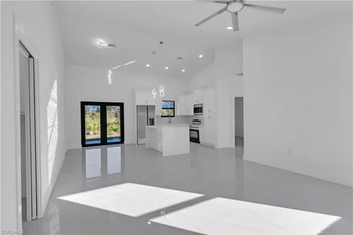 Living room with french doors, high vaulted ceiling, and ceiling fan