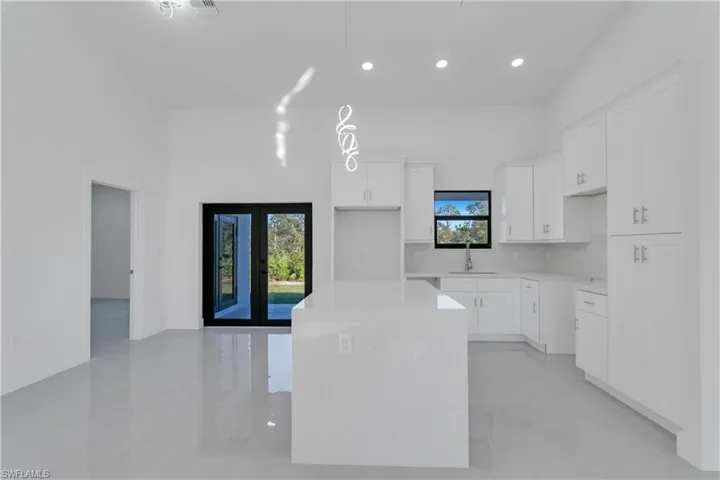 Kitchen featuring white cabinets, plenty of natural light, a kitchen island, and french doors