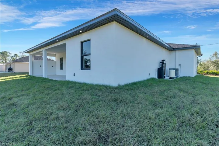 Rear view of house with a yard and a patio