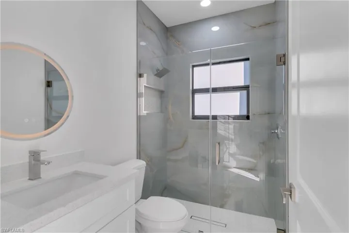 Bathroom featuring vanity, toilet, and walk in shower