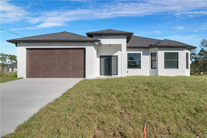 Prairie-style home with a front yard and a garage