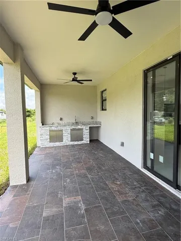 View of patio with an outdoor kitchen and a ceiling fan