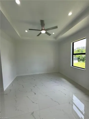 Unfurnished room with a tray ceiling, recessed lighting, and ceiling fan