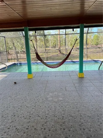 View of swimming pool featuring a lanai