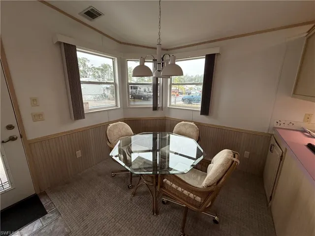 Dining space with ornamental molding and light tile patterned floors