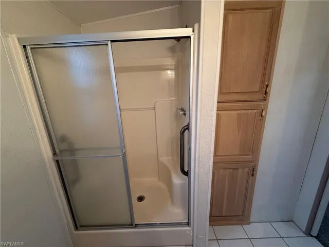 Bathroom featuring walk in shower and tile patterned floors