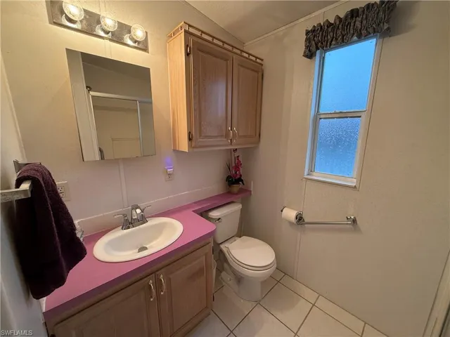 Bathroom with toilet, tile patterned flooring, and vanity