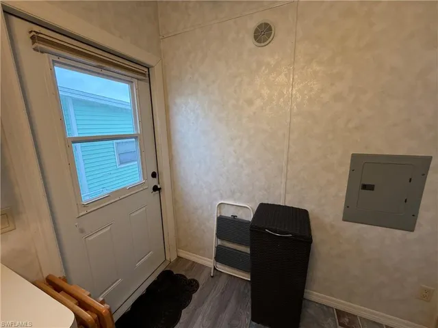 Doorway to outside featuring electric panel and dark hardwood / wood-style flooring
