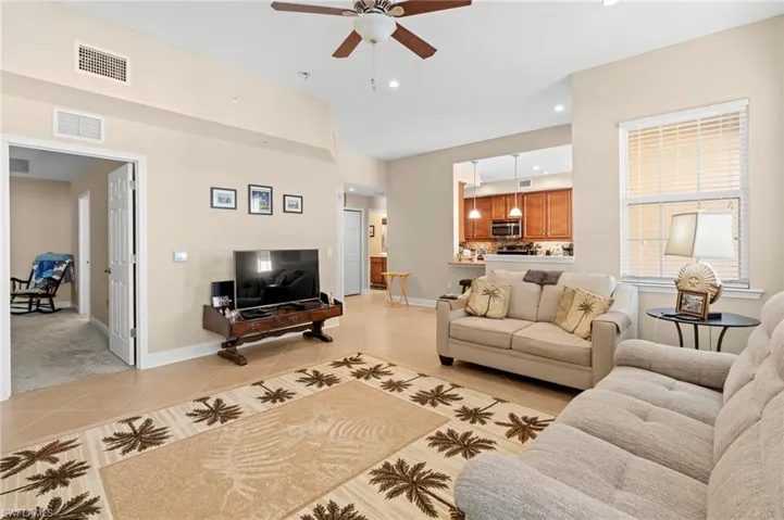 Living room with light tile patterned floors, ceiling fan, and recessed lighting